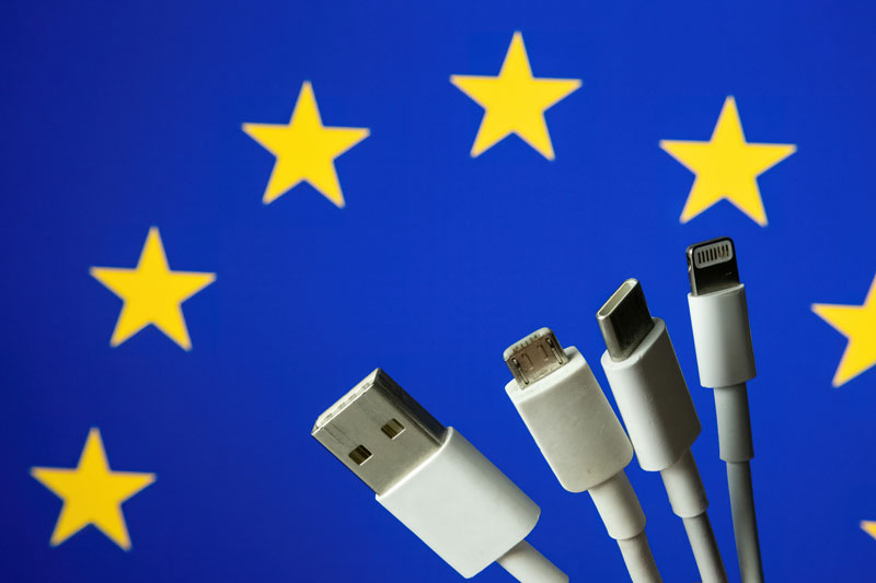 Different charging cables including usb-c in front of an EU flag